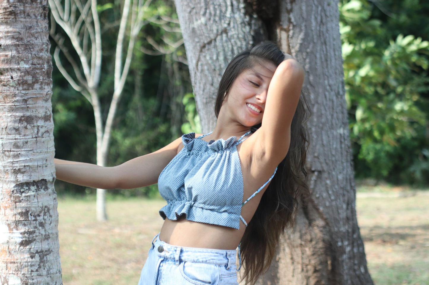 Modelo con el Scrunchie Top en estampado geométrico azul es perfecto para un look fresco y desenfadado. Su diseño de tirantes finos y la cintura fruncida lo hacen cómodo y elegante, ideal para esos días soleados.