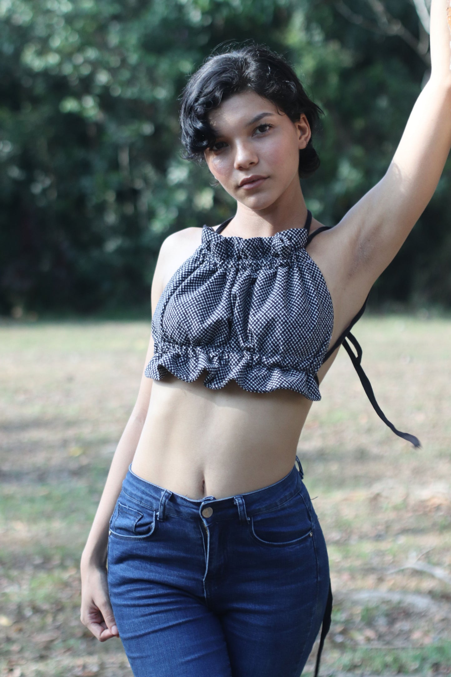 Mujer con el Scrunchie Top en estampado geométrico negro es perfecto para un look fresco y desenfadado. Su diseño de tirantes finos y la cintura fruncida lo hacen cómodo y elegante, ideal para esos días soleados.