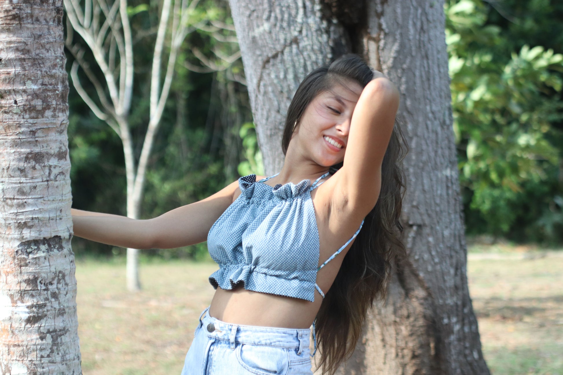 Modelo con el Scrunchie Top en estampado geométrico azul es perfecto para un look fresco y desenfadado. Su diseño de tirantes finos y la cintura fruncida lo hacen cómodo y elegante, ideal para esos días soleados.